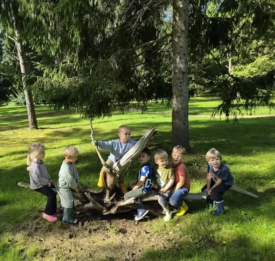 Vaikai sėdi ant rąstų